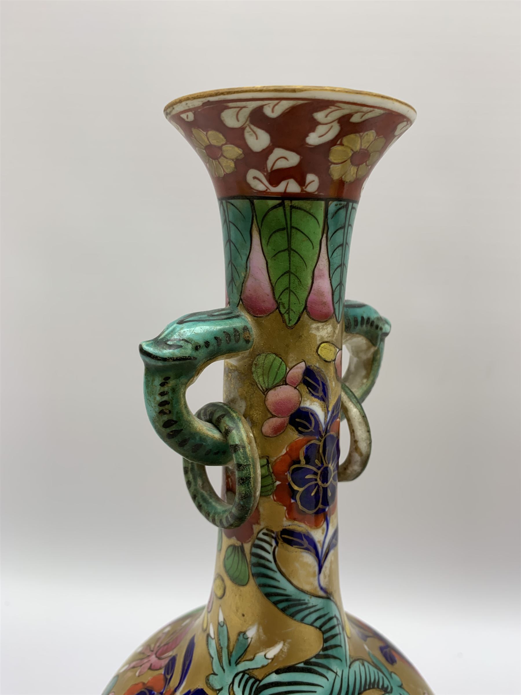 Pair of early 19th century Miles Mason vases, the baluster bodies with tall slender necks supporting twin stylised trunk handles with rings, decorated with Chinese dragons, butterflies, and blossoming flowers against a gilt ground, with spurious Chinese marks beneath in iron red, H27.5cm