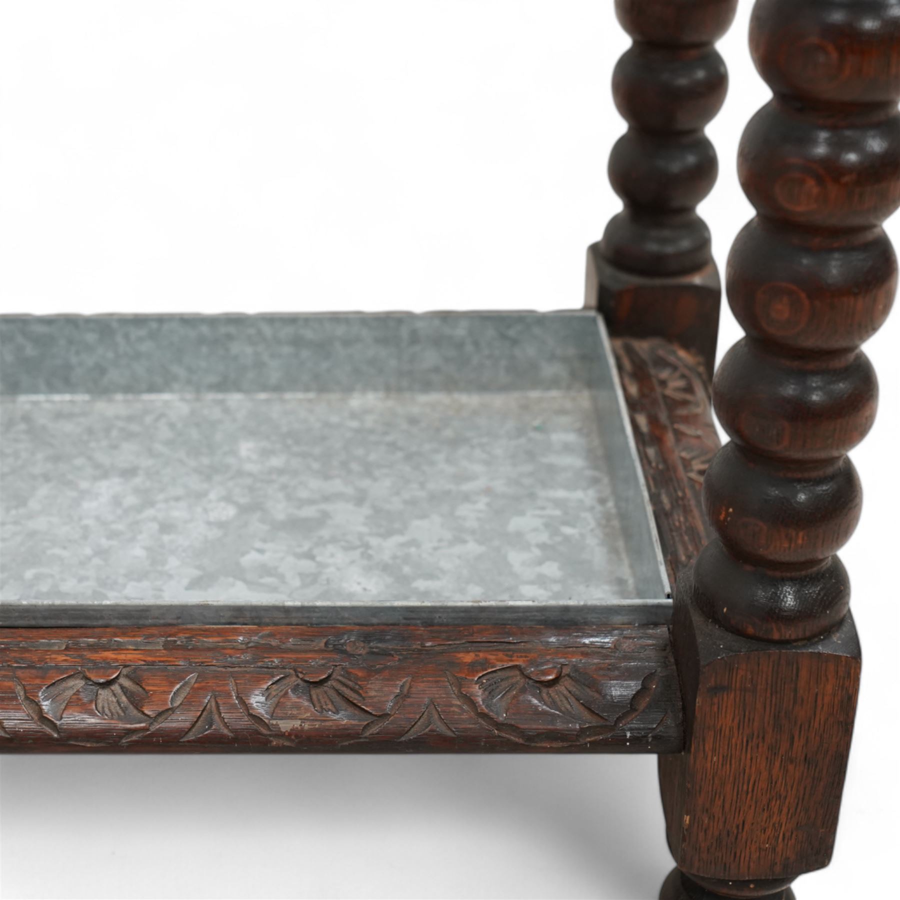 Victorian carved oak stick stand, three divisions within lunette carved frame, on bobbin turned supports united by carved stretchers, with drip tray 
