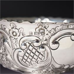 Edwardian silver bowl with embossed decoration on a short pedestal foot D11cm Birmingham 1904 Maker A & J Zimmerman Ltd and a modern silver coaster with turned wooden base D9.5cm Sheffield 2001 (2)