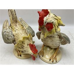 Pair of ceramic fighting Cockerels, with stamped and impressed marks beneath, tallest 20cm