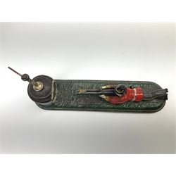 Very rare 19th century John Harper & Co. mechanical cast-iron money box, registered number 33821 patented 1885, inscribed on metal plaque 'Wimbledon Bank', based on the Queen's Trophy for shooting at Wimbledon, depicting a British Infantry man in red tunic and blue trousers lying on the ground using a gun to fire a brass coin launcher into a pill box with removable moving flag above L30cm
