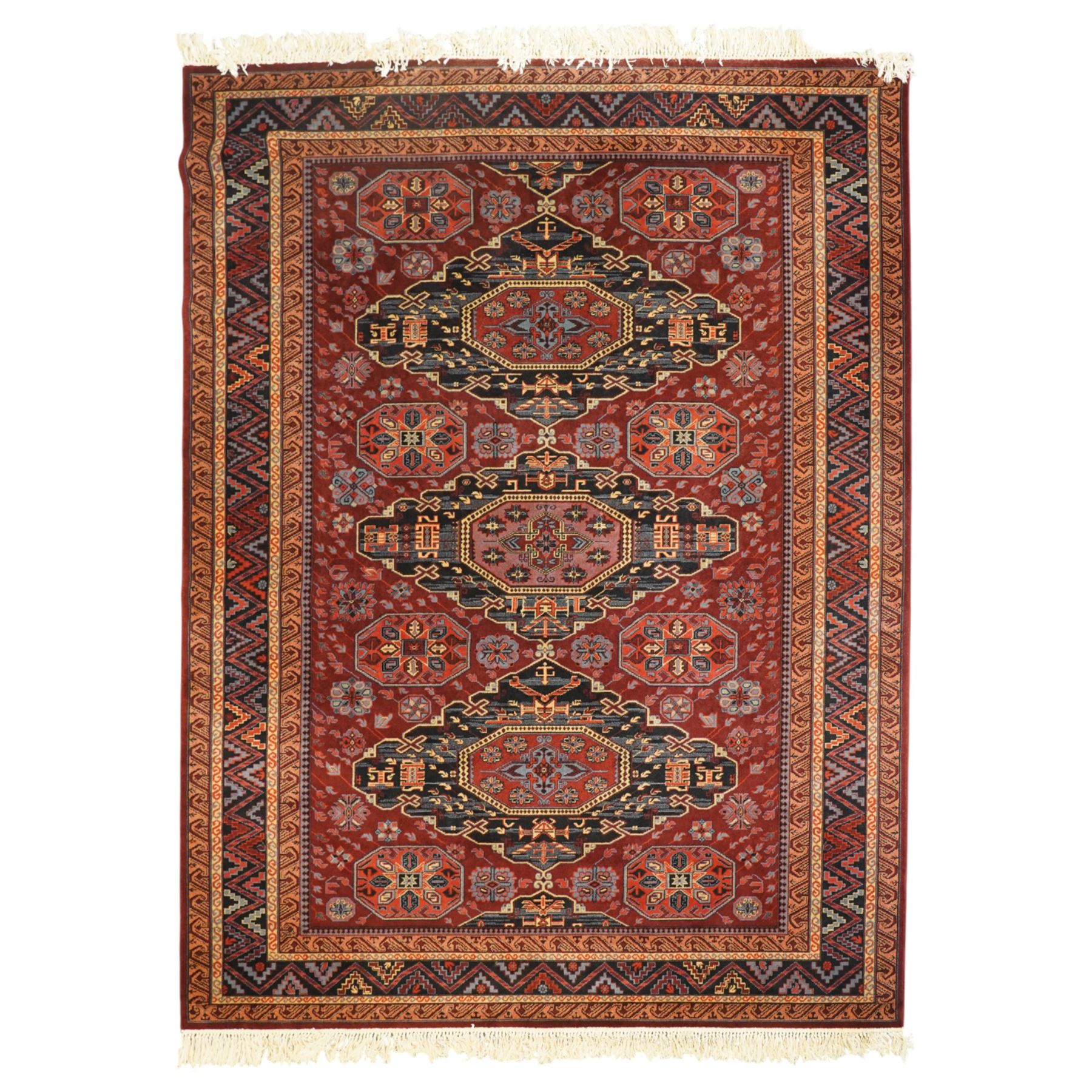 Persian Karabagh design rug, red madder field with three linked octagonal medallions surrounded by floral geometric motifs within multiple stylized borders 