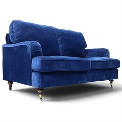 Howard design - two-seat sofa upholstered in blue fabric, traditional shape with rolled arms, on walnut finish turned feet with brushed metal cups and castors