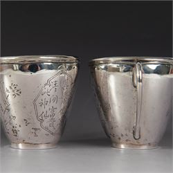 Pair of Chinese export silver teacups, both decorated with character marks, one with floral decoration, the other decorated with a bird within bamboo branches, both with indistinct maker's marks beneath, H6cm