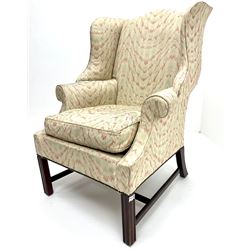Georgian style mahogany framed wingback armchair upholstered in a beige ground fabric, shaped cresting rail, scrolling arms, square fluted supports 