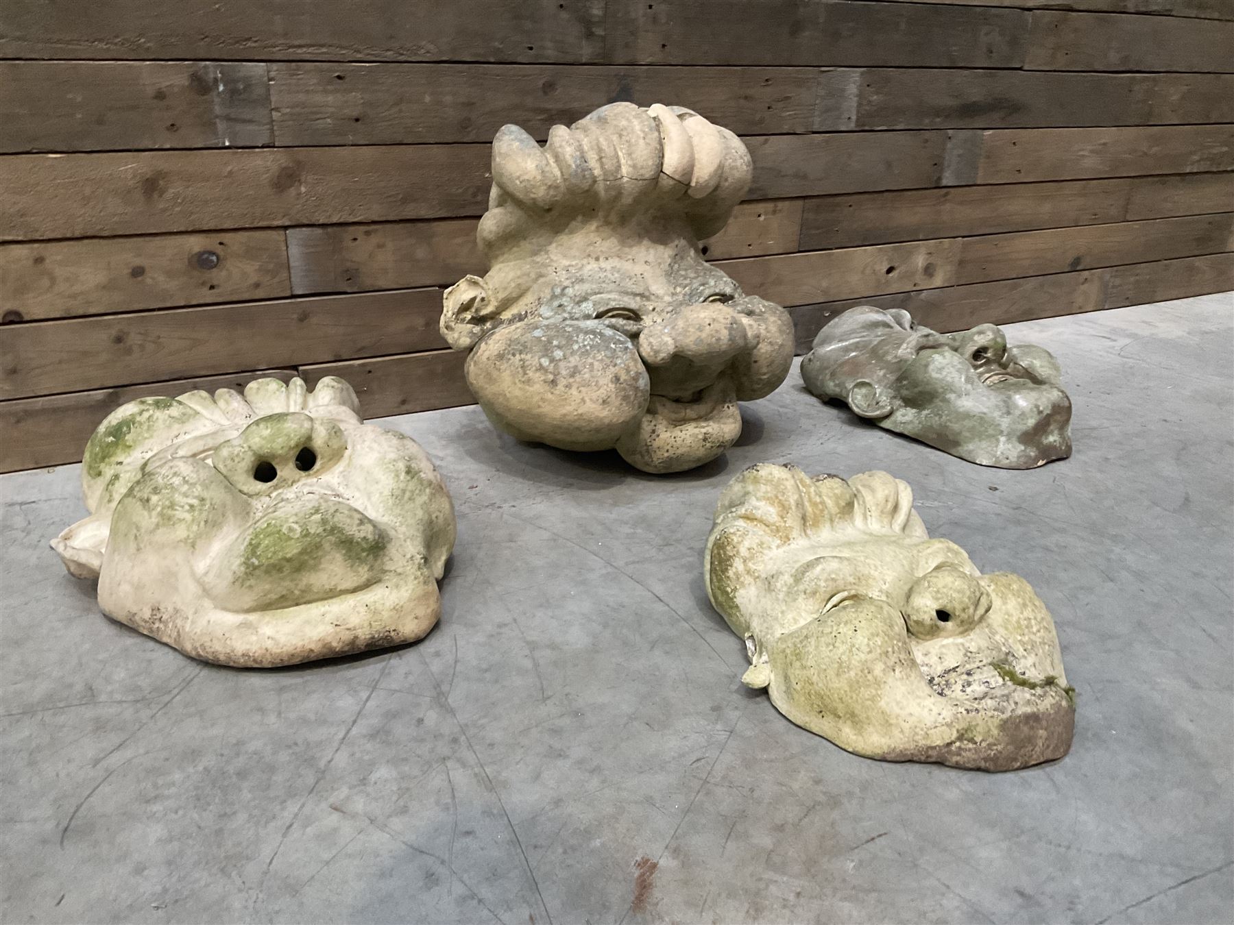Four grotesque garden wall masks