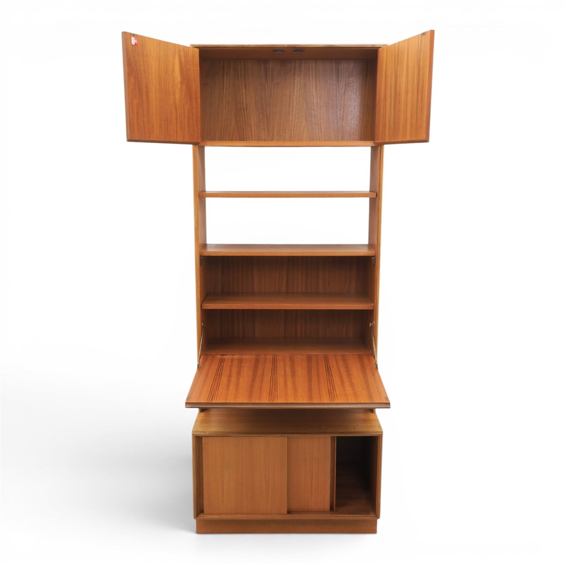G Plan - Mid 20th century teak units, comprising tall shelving unit with cupboard sections, fall front and open shelves, together with a low twin-door cupboard unit, on plinth bases

Low unit: H 53cm, D 46cm, W 81cm
Tall unit: H 199cm, D 46cm, W 76cm