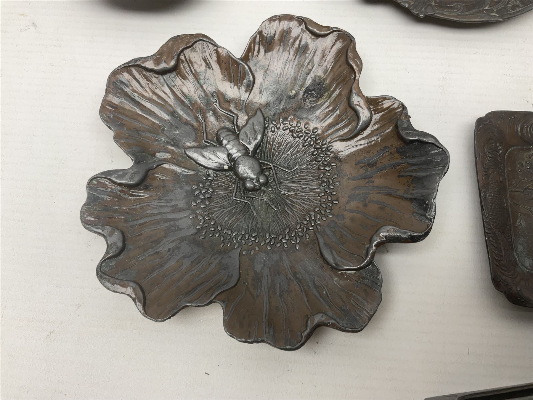 Brass sunfish ashtray, Chinese silver plated trinket box with mirror, bronzed matchbox cover and a collection of other Oriental bronzed embossed metal trays