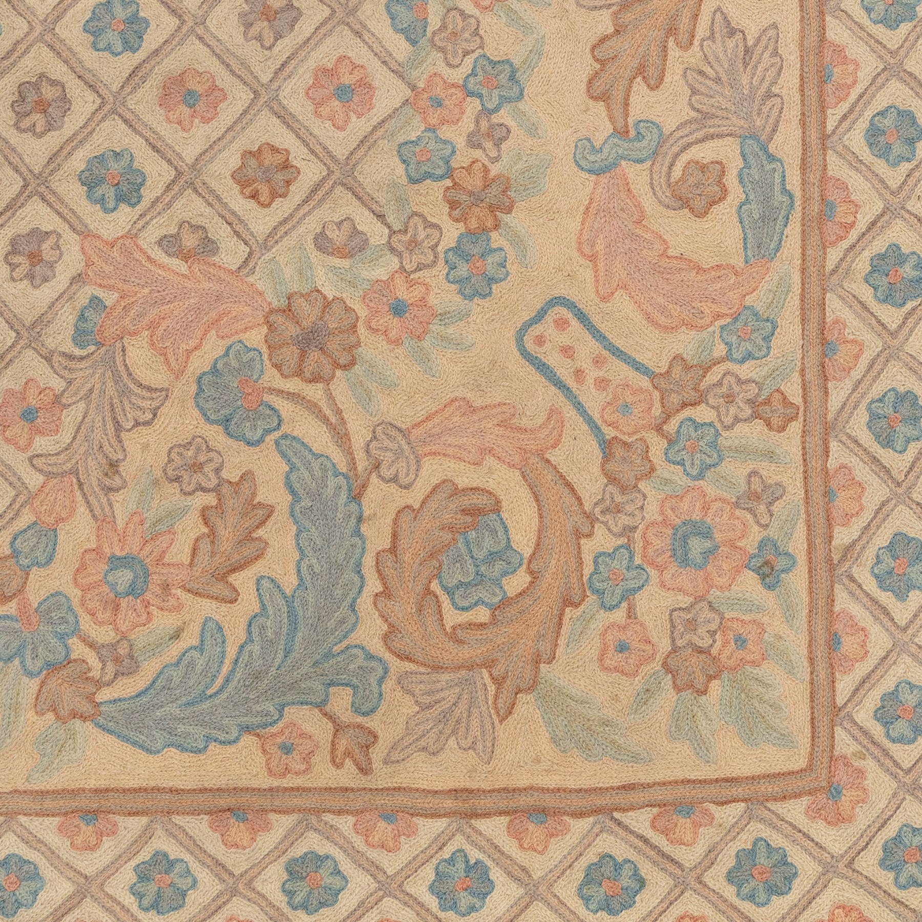 Aubusson design pale peach ground rug, woven with an all-over lattice design in rose and cyan with central floral bouquet medallion, the scrolling acanthi and flowerhead spandrels contained within a lattice guard band