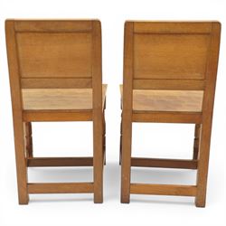 Mouseman - pair of oak panel back side chairs, adzed panel back and seat, on octagonal supports, with carved mouse signature, by the workshop of Robert Thompson of Kilburn