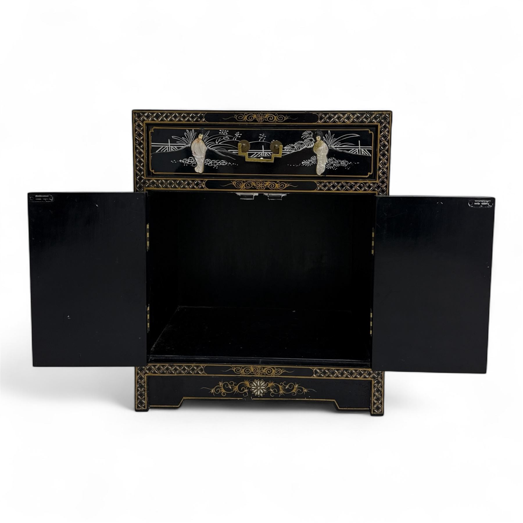 20th century Japanese Shibayama style black lacquered cabinet, rectangular form decorated with mother-of-pearl and hardstone figural inlay, the top with four standing figures, single frieze drawer above two cupboard doors, gilt painted borders and landscape