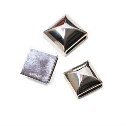 Hermès - two ‘Bolduc’ silk Twilly scarves, in orange/black and navy/brown colourways, together with three palladium-tone Médor pyramid Twilly scarf rings, with original dust bag and cylindrical box
