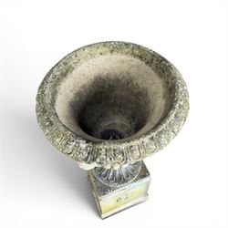 Cast stone classic garden urn, the rim decorated with leaves and berries, twin handles with face masks, raised on square base, stamped HGC
