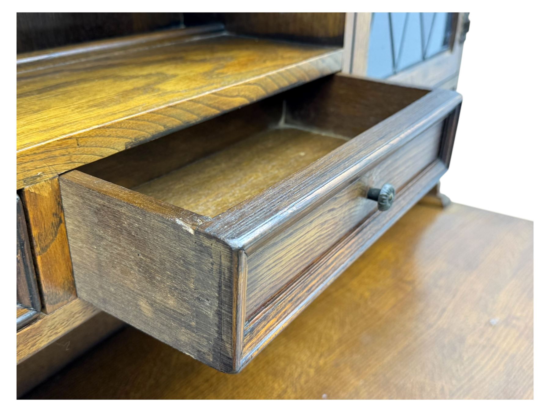 Large mid-20th-century oak dresser with two astragal glazed doors between gallery shelf and lower shelf, with three short drawers and lower section with four drawers and three double-panelled linen-fold hinged cupboard doors 