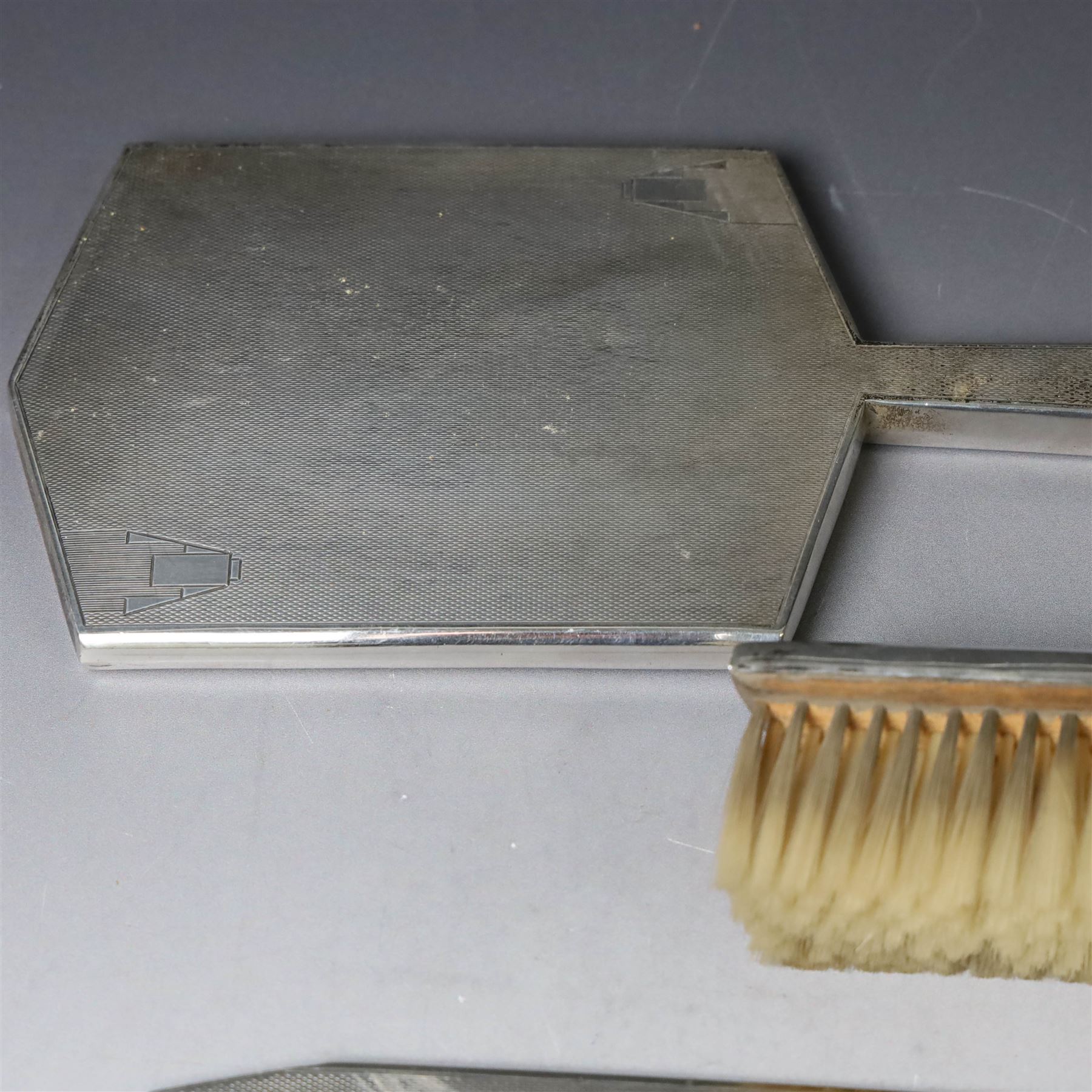 Mid 20th century silver mounted dressing table set, comprising hair brush, clothes brush, hand mirror and comb, each with engine turned Art Deco style decoration, all hallmarked Walker & Hall, Sheffield 1954 &1955