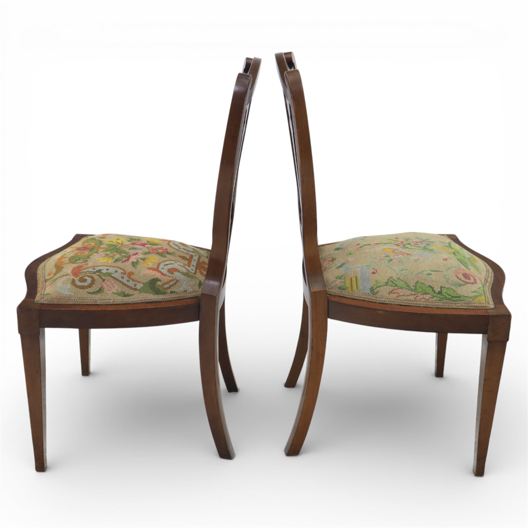 Edwardian pair of satinwood inlaid shield back chairs, the pierced shield shaped backs with central splats inlaid with floral and foliate motifs, tapestry upholstered serpentine seats, raised on square tapering supports