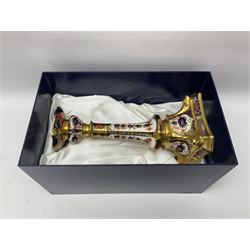 Pair of modern Royal Crown Derby Old Imari 1128 pattern candlesticks, each with shaped drip tray affixed to squat socket, upon spreading stem and canted square base with gilt dolphin edges, with printed marks beneath including Roman numeral year cypher for 2003, H26.5cm, with original boxes