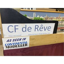 'Z' gauge continental scenic layout with folding legs, various loops of track and sidings with overhead cables, buildings including water tower, tunnels, roads with motor vehicles and figures, trees, haven with boats, backdrop diving wall hiding control units 150 x 50cm