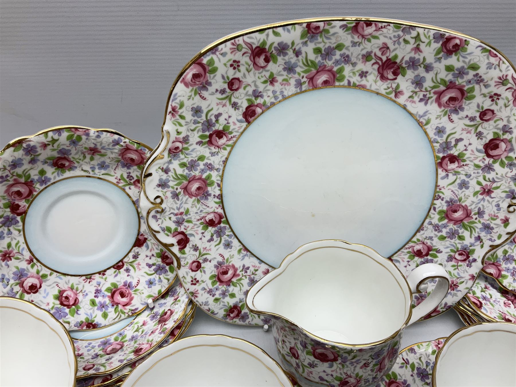 Windsor tea service for six decorated with blooming pink roses and purple flowers amongst foliage