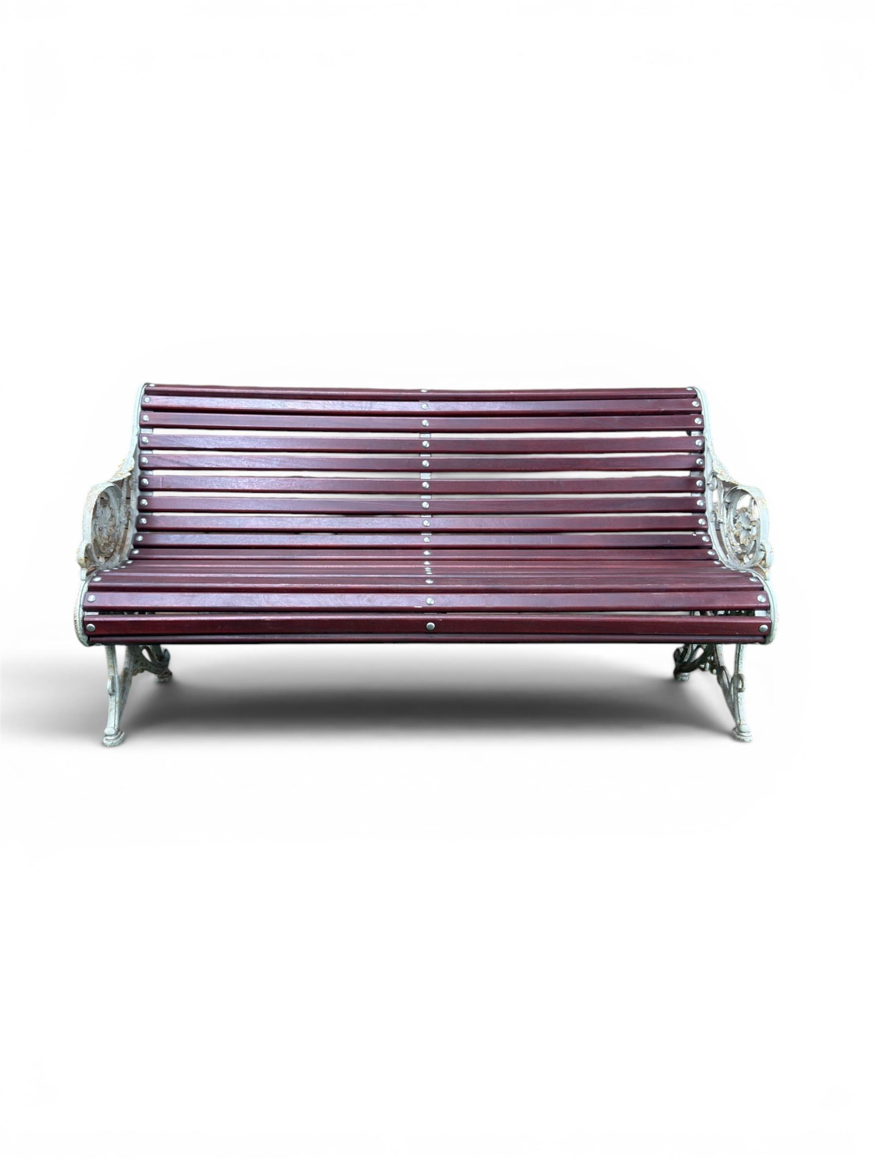 Large late Victorian cast iron garden bench, serpentine form with scroll back and seat, slatted with mahogany stained Sapele