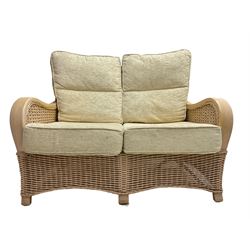 Contemporary rattan conservatory suite - two seat sofa with wicker frame and loose cushions upholstered in textured champagne fabric (W125cm H98cm); pair of matching armchairs (W72cm H98cm); rectangular glass-topped coffee table with rattan frame and undertier (W85cm D60cm H47cm); and matching square side table (W53cm H55cm)