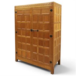 Mouseman - early-to-mid-20th century panelled and adzed double wardrobe, the arcade carved cresting rail over two panelled doors, with wrought metal hinges and latch, deep relief carved mouse signature, the interior fitted with hanging rail, by the workshop of Robert Thompson of Kilburn