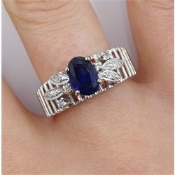 14ct white gold open work and leaf design ring, set with a singe oval sapphire and round diamonds