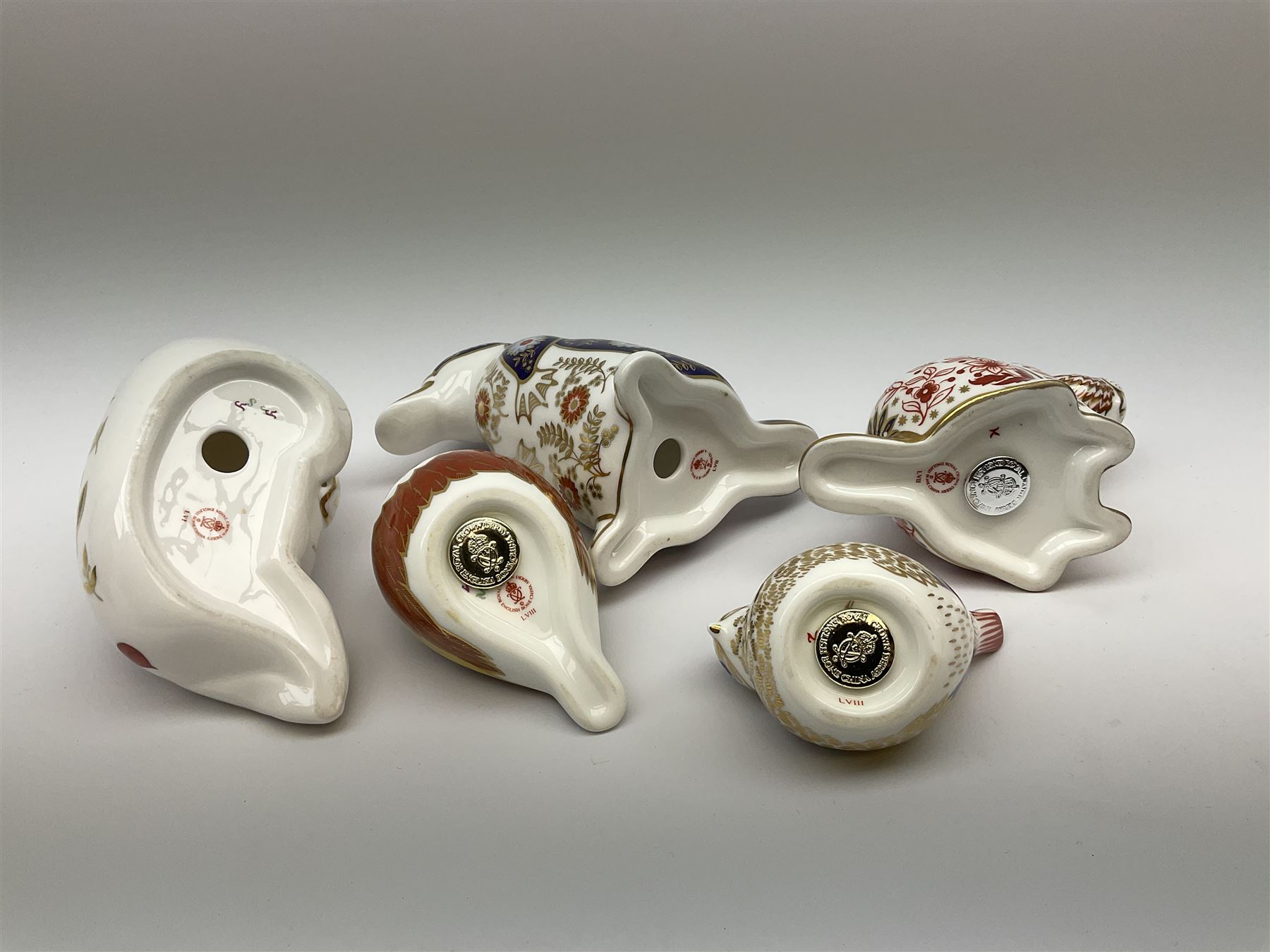 Five Royal Crown Derby paperweights, comprising Chaffinch, and Goldcrest, each with gold stopper, and box, example modelled as a Beaver with silver stopper, and two further examples lacking stoppers. 