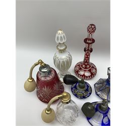 Bohemian flashed and overlayed perfume bottles and atomisers, to include a blue bohemian example of octagonal form with gilt detailing and petal cut stopper, cranberry examples, and a number of clear cut and moulded glass with faceted edges