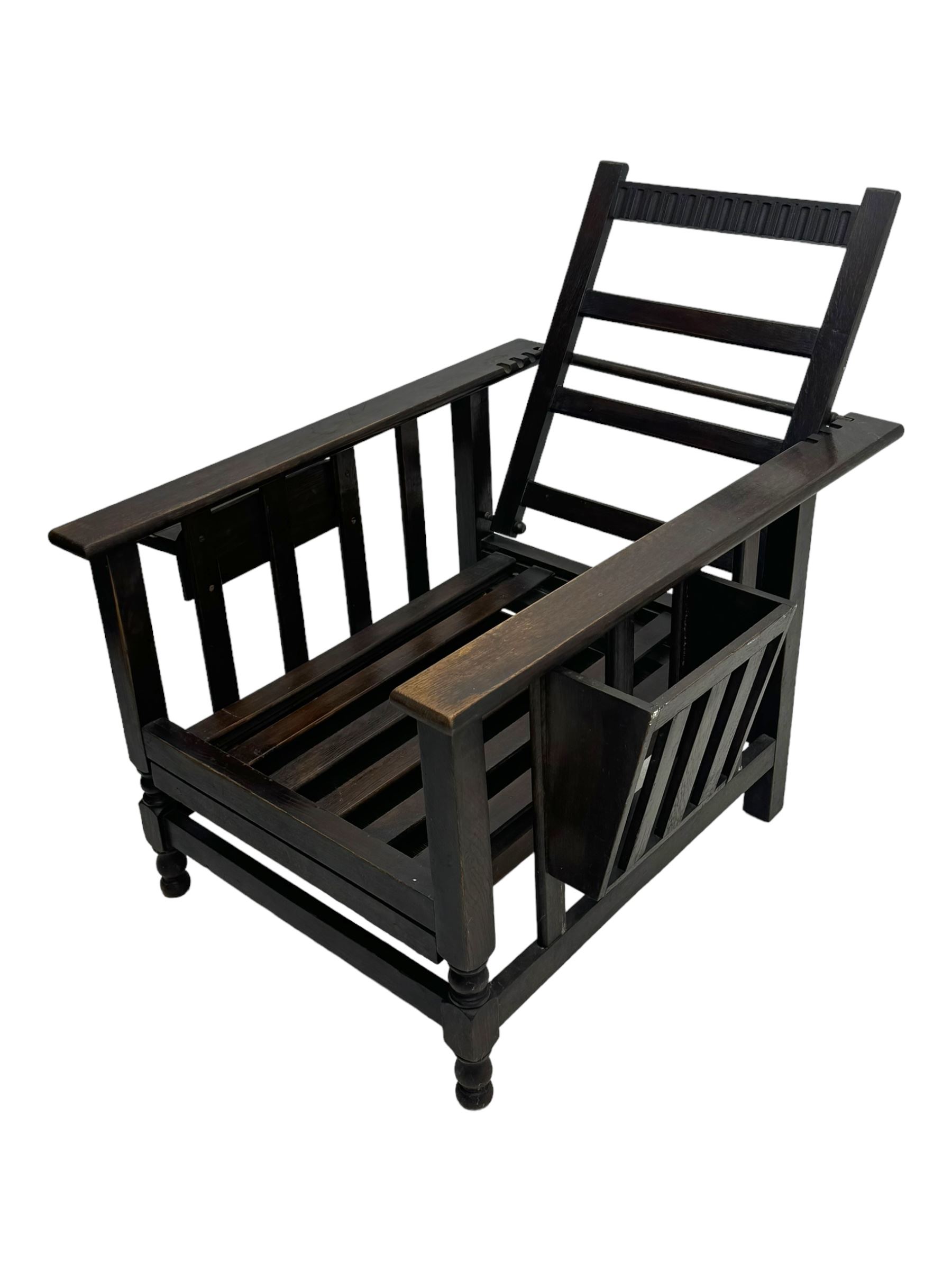 Late Victorian oak steamer chair, adjustable slatted backrest with grooved crest rail, wide armrests extending to a sliding adjustable footrest, open frame sides with vertical slats, side magazine rack and collapsible table, raised on turned front supports