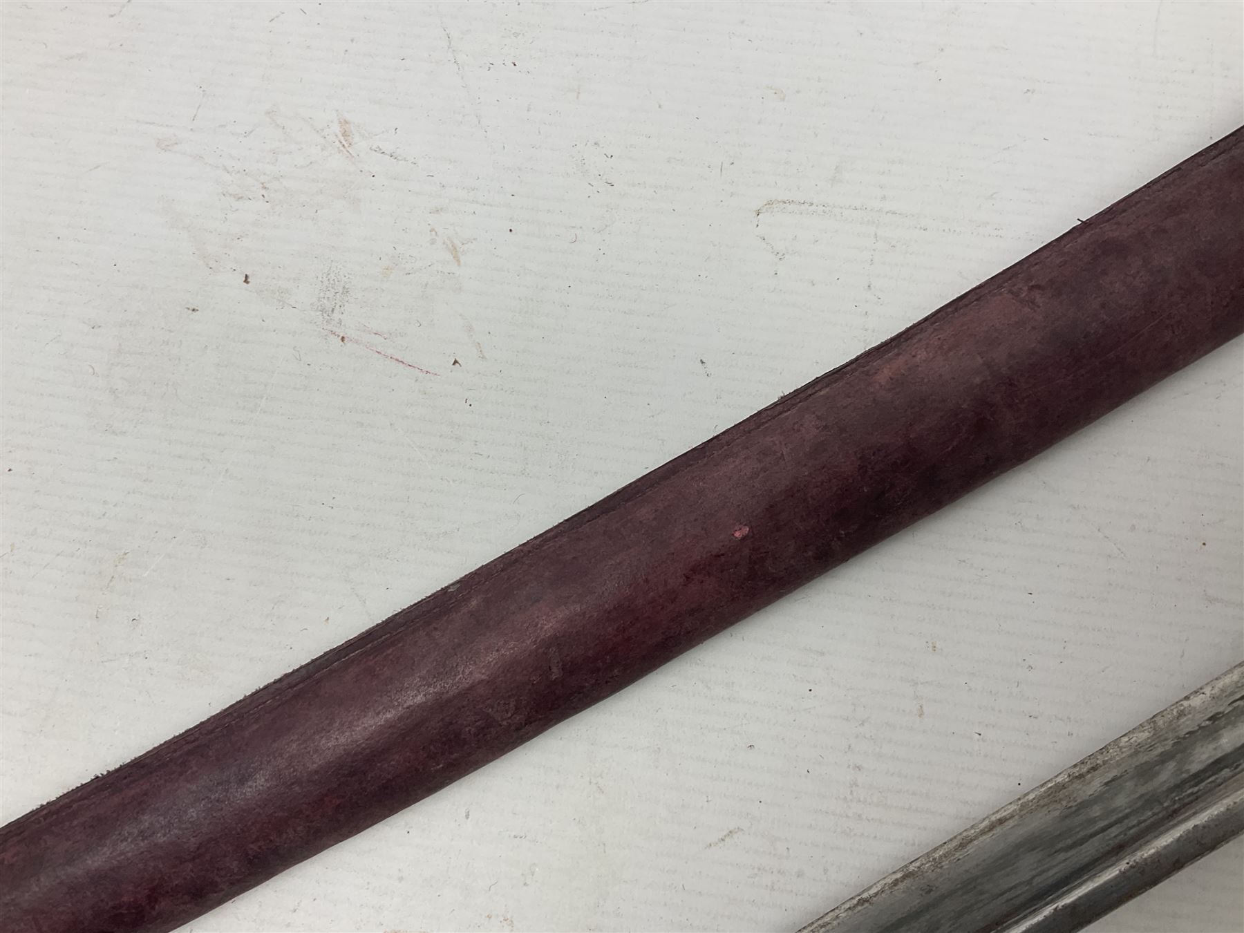 Copy of a WWII Japanese NCO sword, the 65cm slightly curving blade stamped with pseudo Japanese characters and cast brass simulated cord bound grip; in officer's leather bound field scabbard L97cm overall