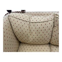20th century Knole design two seat sofa, high back and double drop-arm joined by mahogany finials and ties, upholstered in camel ground fabric with red lozenge design, on turned supports with brass castors