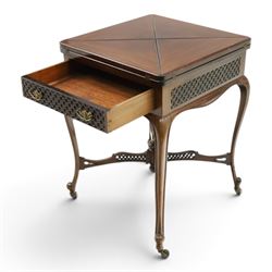 Edwardian carved mahogany envelope card table, the rectangular quadruple hinged top enclosing baize-lined interior, the single frieze drawer and sides with blind-fretwork carving, over cabriole supports with scroll feet and castors united by pierced lattice fretwork X-stretcher with turned finial