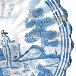 18th century Dutch Delft plate of fluted design decorated in blue and white with figures in a landscape D29cm and a Dutch Delft vase decorated in blue and white with oriental flowers H21cm (2)