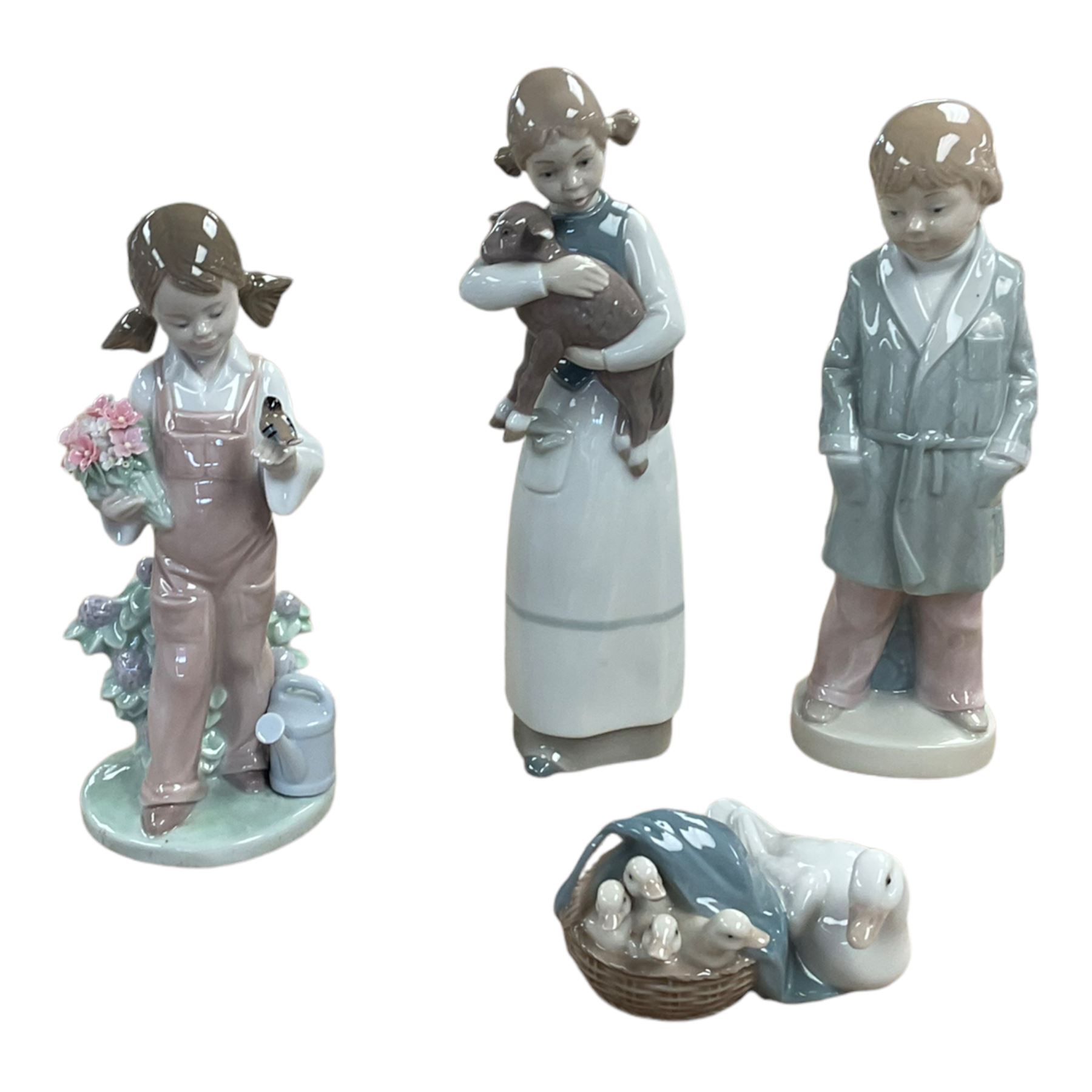 Four Lladro figures, including Girl holding bird no 5217, Duck and Ducklings no 4895 etc, together with Nao and similar figures 