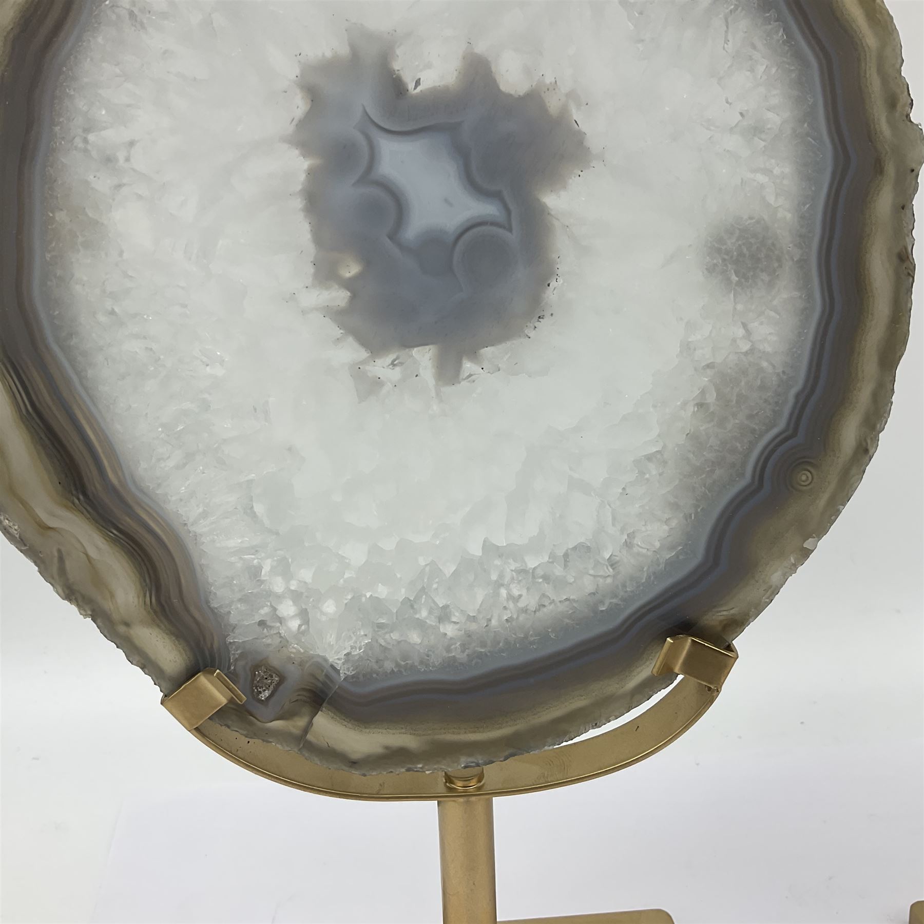 Pair of white agate slices, polished with rough edges raised upon gilt metal stands, H24cm