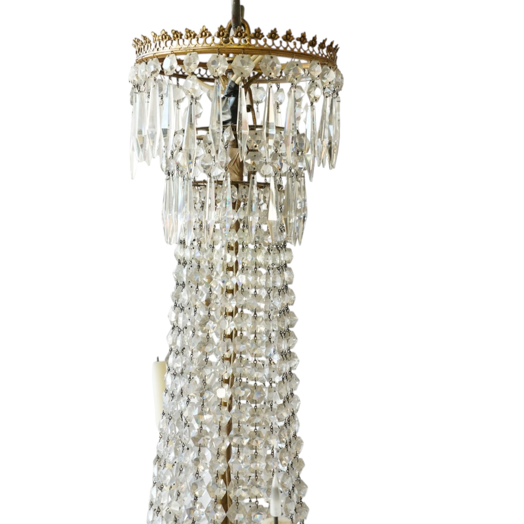 Regency Country House cut-glass and ormolu six light chandelier, the outer shaft with ormolu foliate moulding hung with octagonal and drop pendants, the impressive central shaft with cascading drops of cut-glass, the scroll branches with hob-nail cut candle holders and wax pans, with central similarly cut terminal
Provenance: property of a nobleman