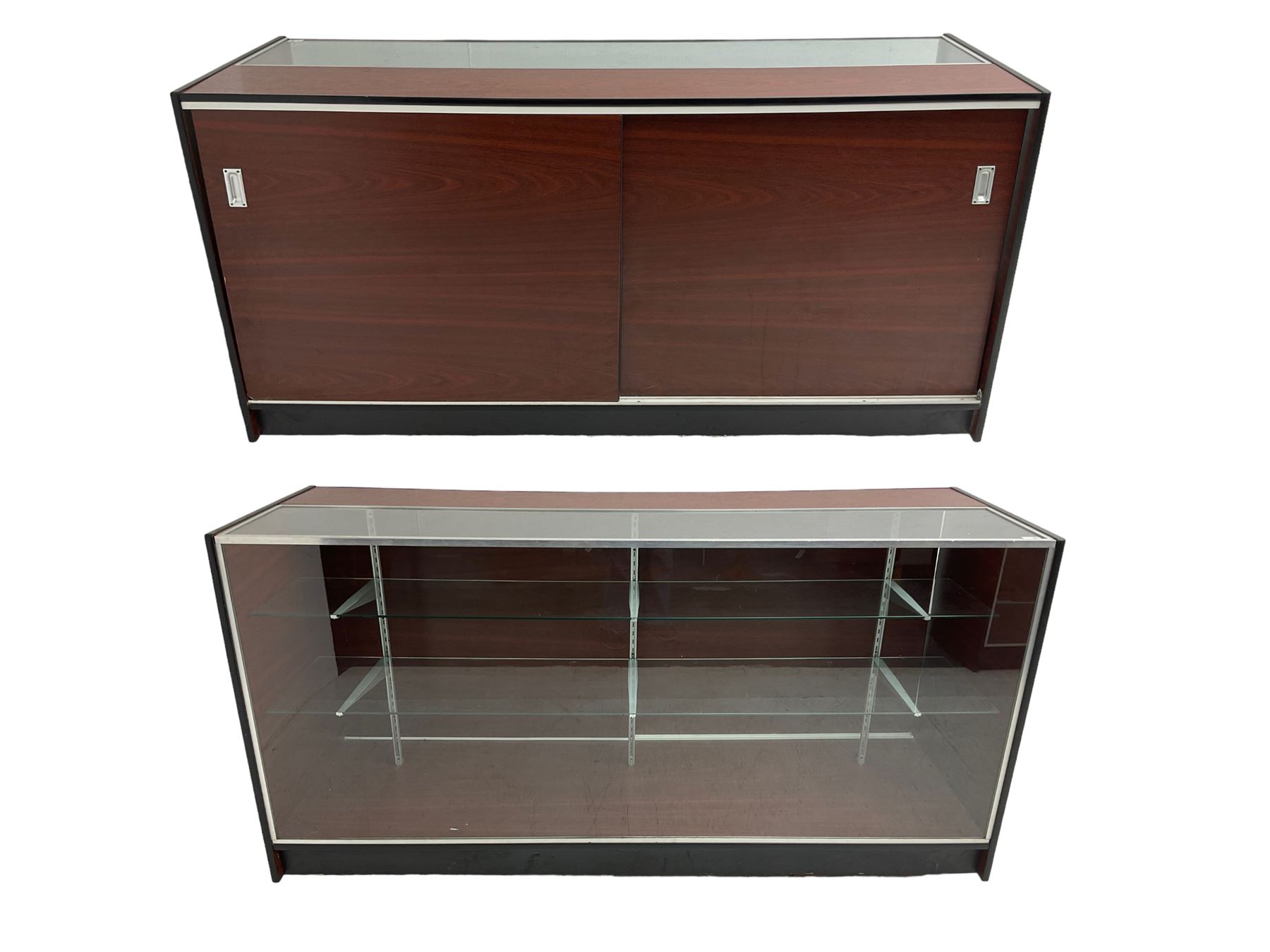 Shop display cabinet counter, glazed front and top, with mahogany laminate sides and back, enclosing two long adjustable shelves, fitted with two sliding cupboard doors to the rear, on castors