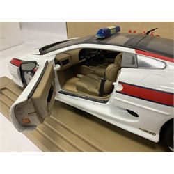 Two Maisto 1:12 scale Jaguar XJ220 scale cars comprising 1992 ‘Concept Car’ West Midlands Police car and 1994 ‘Jag 999’ Thames Valley Police Traffic Car, both on plinths with original boxes and certificates of authenticity 