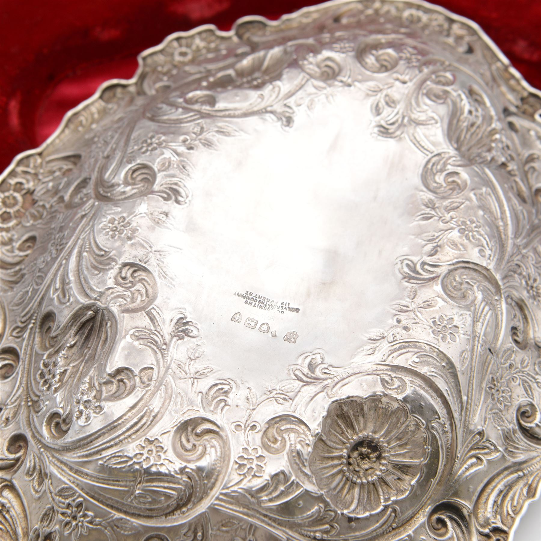 Victorian silver berry dish, of oval form, profusely embossed with floral and foliate decoration, hallmarked Goldsmiths & Silversmiths Co (William Gibson & John Lawrence Langman), London 1894, and a Victorian silver berry spoon, the gilt bowl embossed with berries, hallmarked London 1846, maker's mark worn and indistinct, contained within a tooled leather retailers case for Goldsmiths & Silversmiths London, both also with French weevil import marks, bowl end to end W27cm