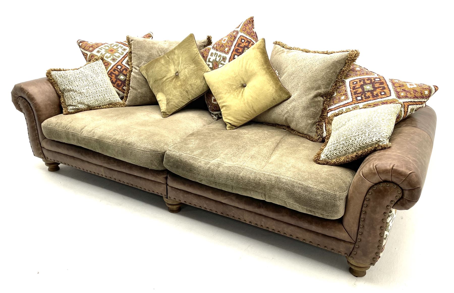 Alexander James - Grand two sectional sofa upholstered in studded leather and fabric, with contrasting kilim patterned scatter cushions, scrolling arms and turned front supports 