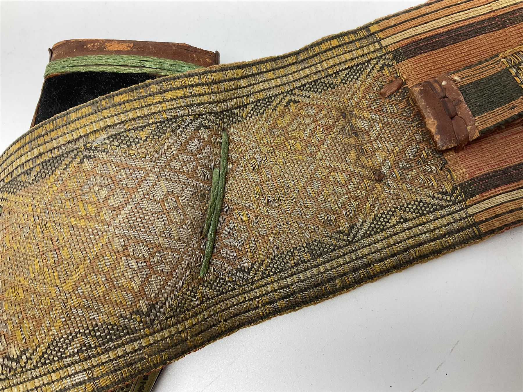 Late 19th century Yemeni Tuza jambiya as worn by religious elite, the 20.5cm curving blade with raised medial ridge, the horn hilt with pique style studwork, in a leather wrapped wooden scabbard with pierced metal mount and leather belt applied with embroidered 'gold' and 'silver' thread work panel; dagger L36cm overall, belt L84cm