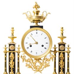 French-Early 19th century 8-day ormolu and polished black slate portico clock, case surmounted with a twin handled urn with flowers, supported by two square pedestals with finials and trailing floral mounts on oval bases, raised on an oval plinth with toupie feet, enamel dial signed 