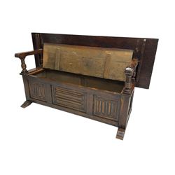 Jacobean design oak Monks bench, the front with carved linenfold panels, hinged metaphoric table back, hinged box seat compartment, on sledge feet