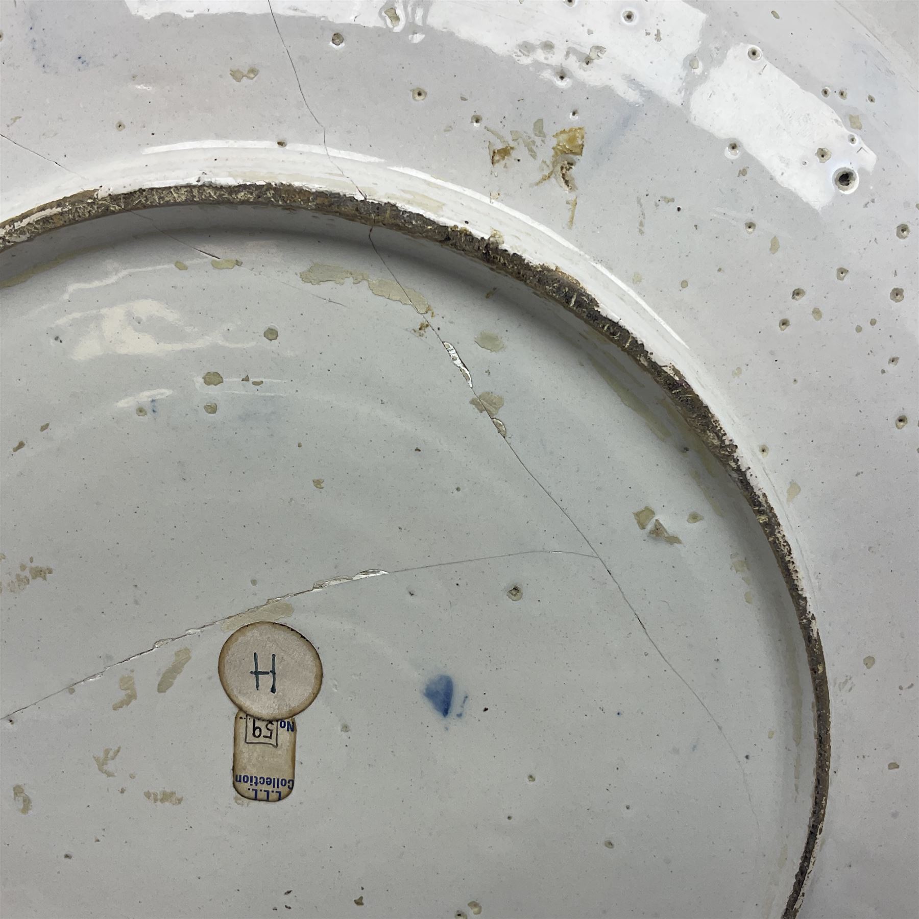 Early 18th century Delft marriage plate, of circular form with dished centre, the centre inscribed and dated 'Thomas and Elizabeth Kockerill Bridlington Key 1715' within a crowned C scroll cartouche, flanked by demi-griffins, above a putto head and tassels, within a wide foliate border, D34cm
