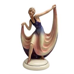 Early 20th century Hertwig Katzhütte figure of an Art Deco lady dancing, wearing a pink and purple dress, stood upon on a domed plinth, with green cat H house printed mark beneath, H32cm