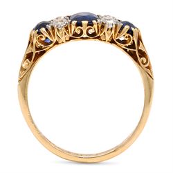 Early 20th century gold sapphire and diamond ring, three vari-cut sapphires, spaced by four old cut diamonds, with scroll design shoulders, stamped 18ct, total sapphire weight approx 1.45 carat, total diamond weight approx 0.30 carat