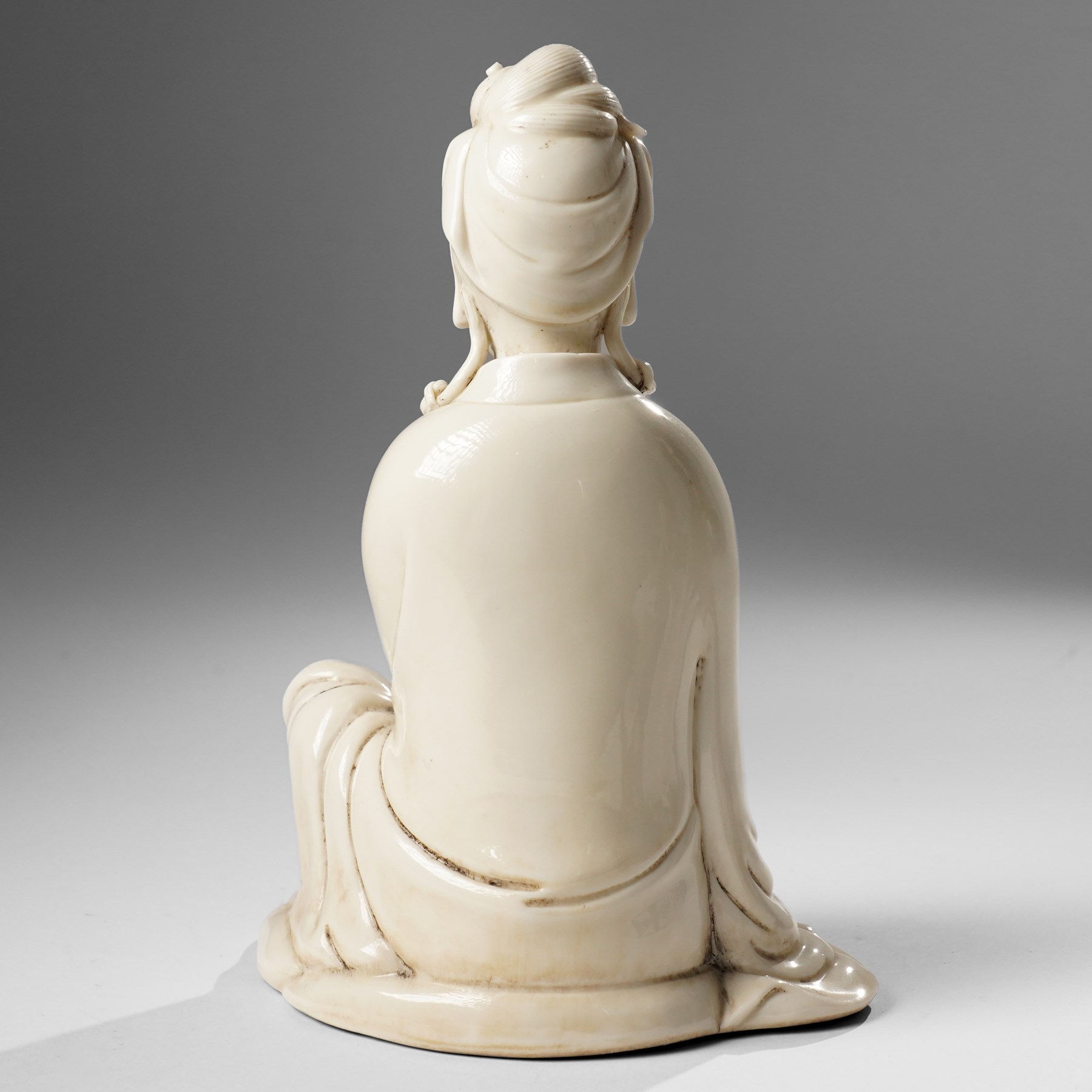 Three Chinese blanc de chine figures, each depicting Guanyin seated, Dehua province, two with double gourd and potters seal marks to the reverse 