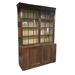 Early 19th century stained pine bookcase on cupboard, fitted with two astragal glazed doors above two cupboards, W153cm, D49cm, H321cm