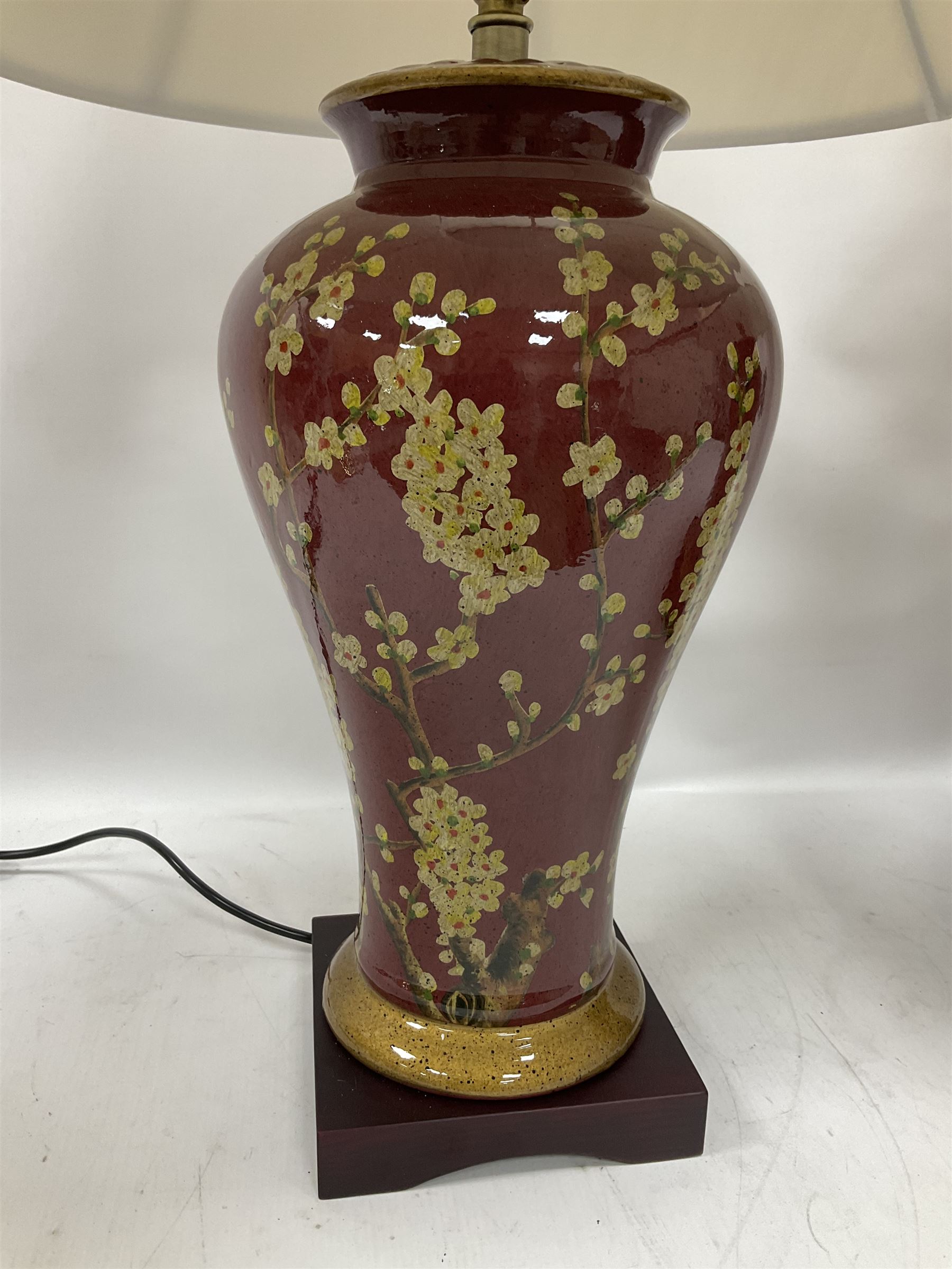 Pair of large table lamps of tapering form, decorated with Japanese blossom on a red ground, upon a square base, including shade H72cm